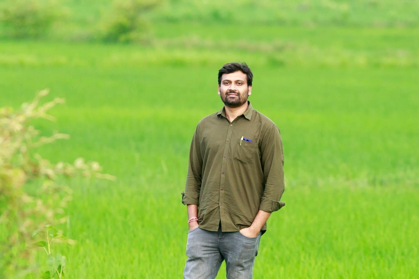 Sawan Bahekar standing in a bright green paddy field in Gondia district